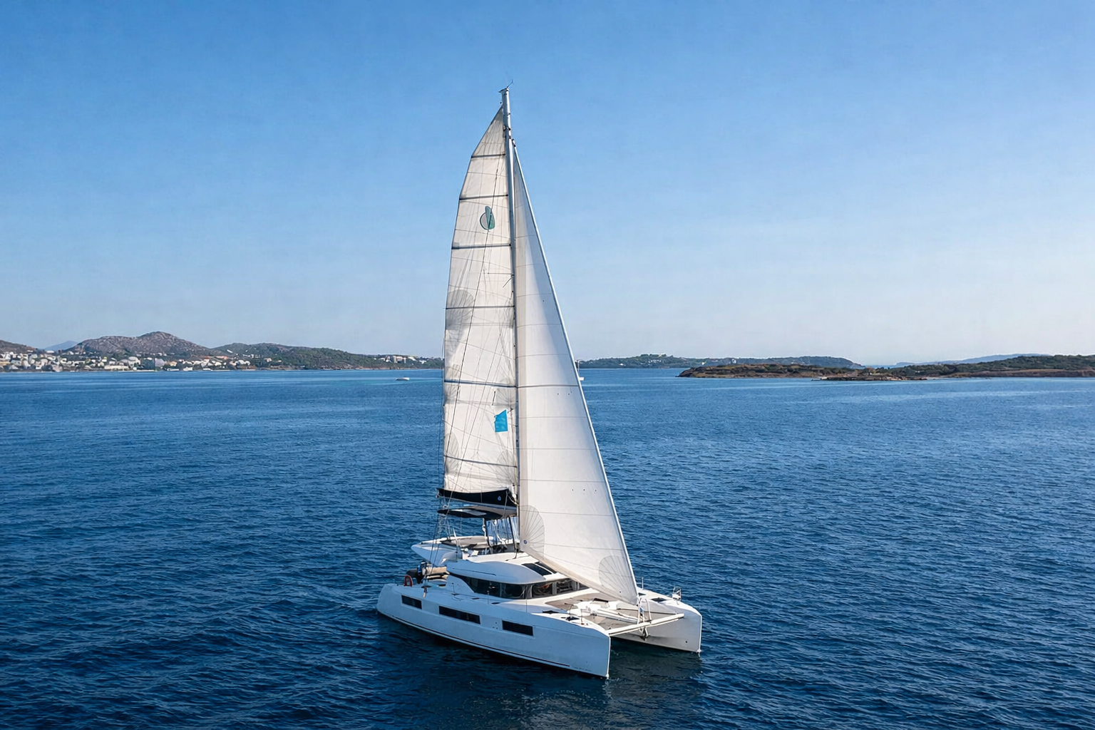 Catamaran sailing with full sails through the Cyclades