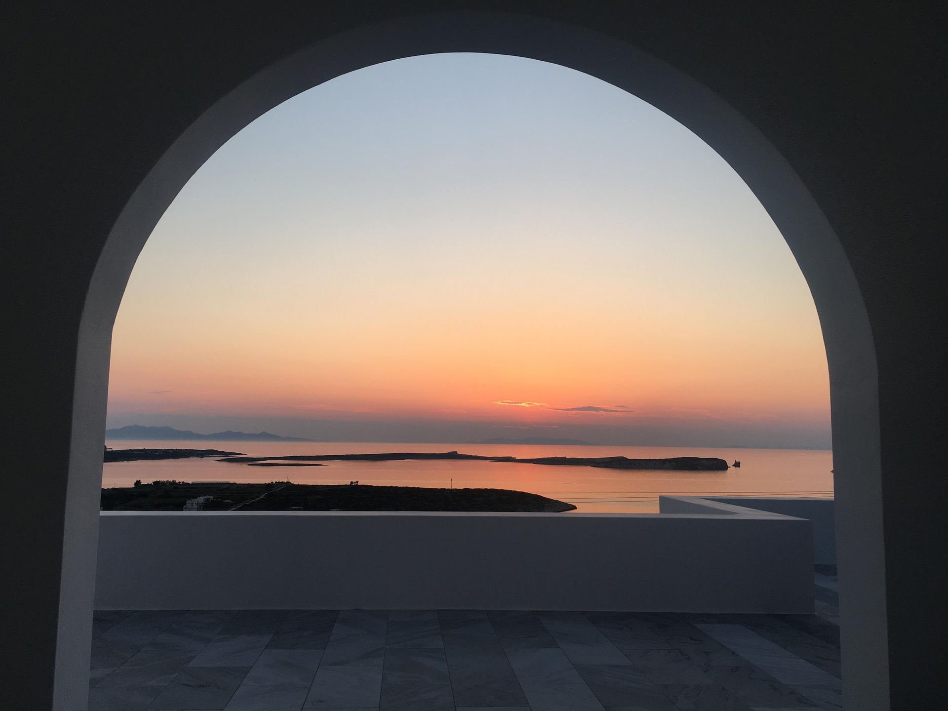 Paros villa sunset through Cycladic arch