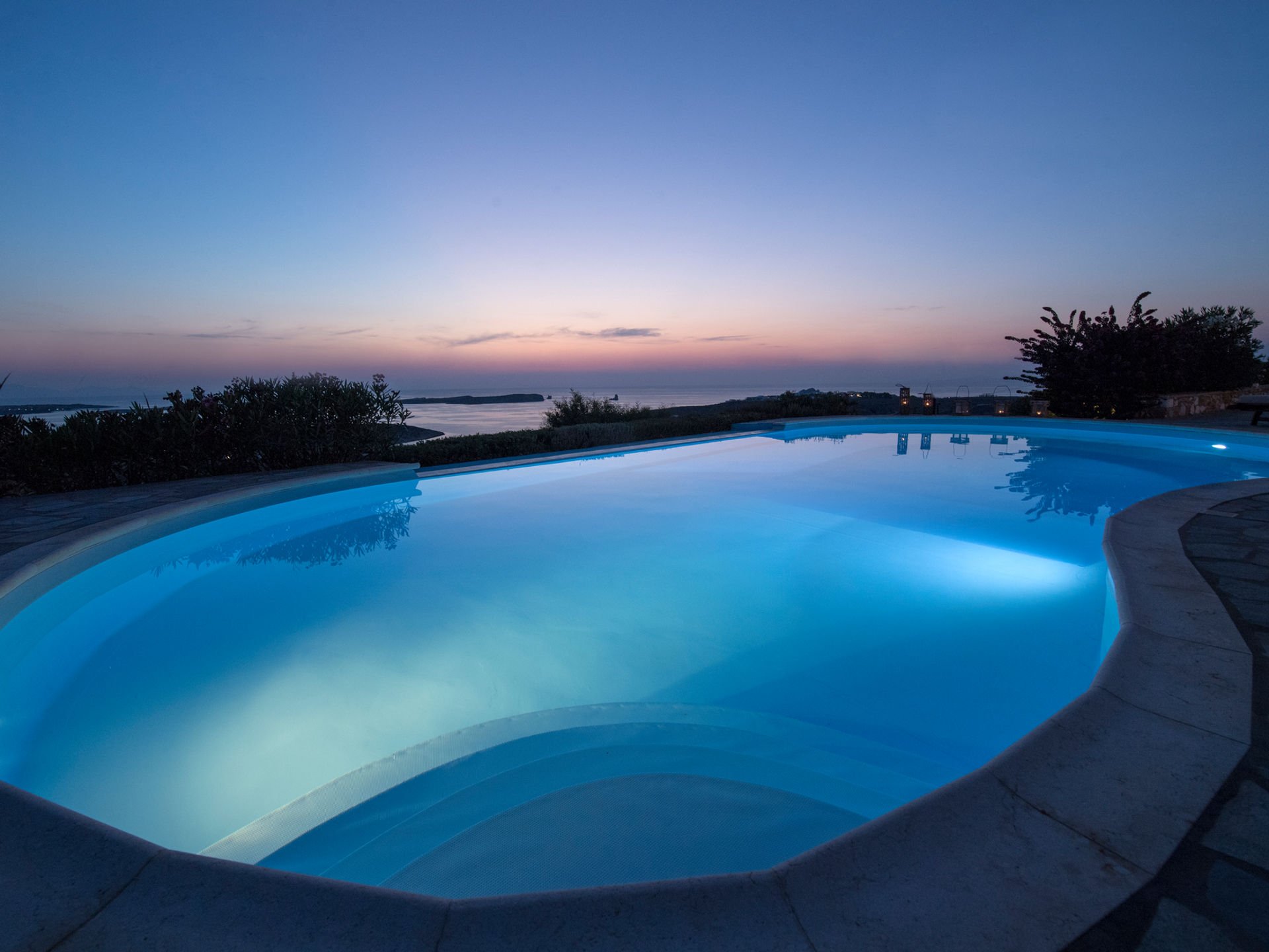 Paros villa pool illuminated at twilight
