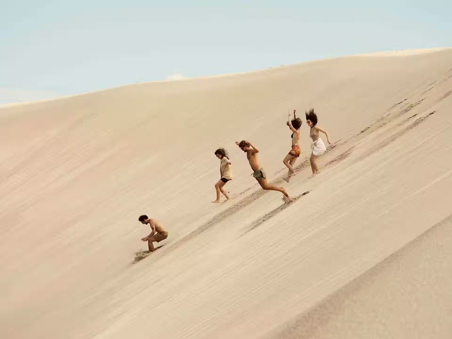 Prea group running down sand dunes