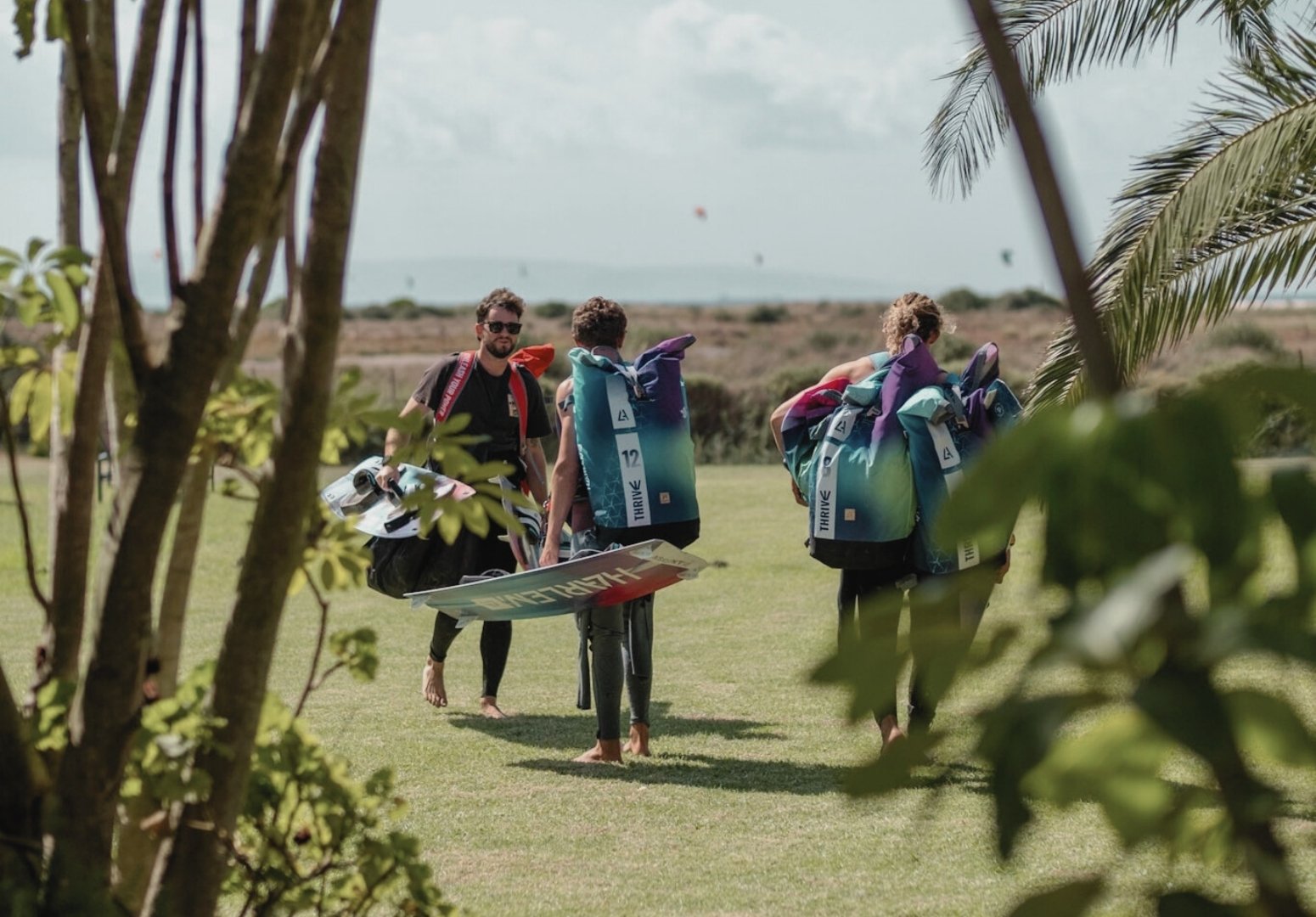 Kitesurfers walking through the villa garden to the beach