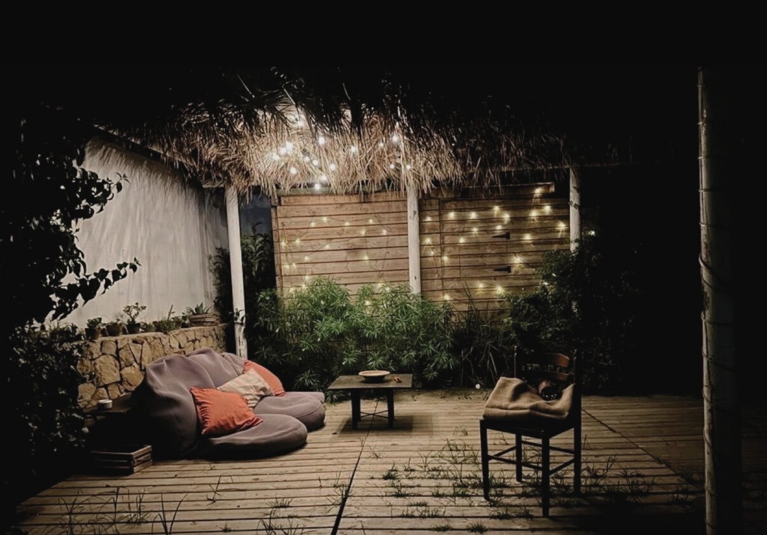 Tarifa villa terrace lounge with string lights at night