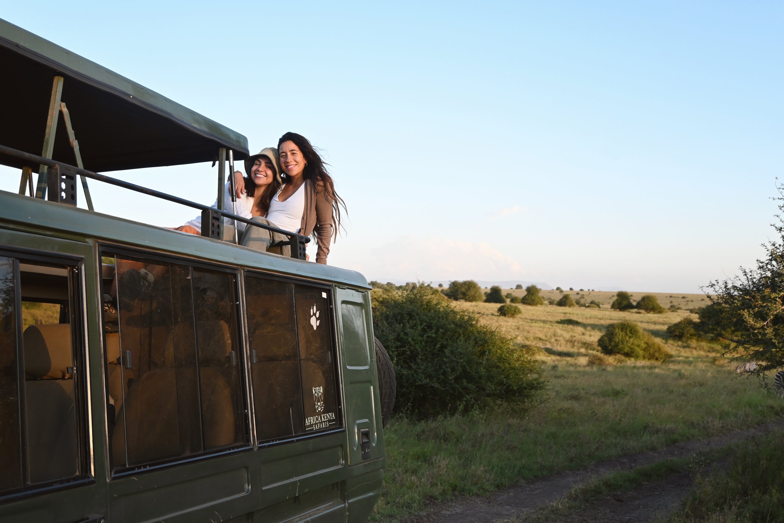 Two women poking out of open-top safari jeep