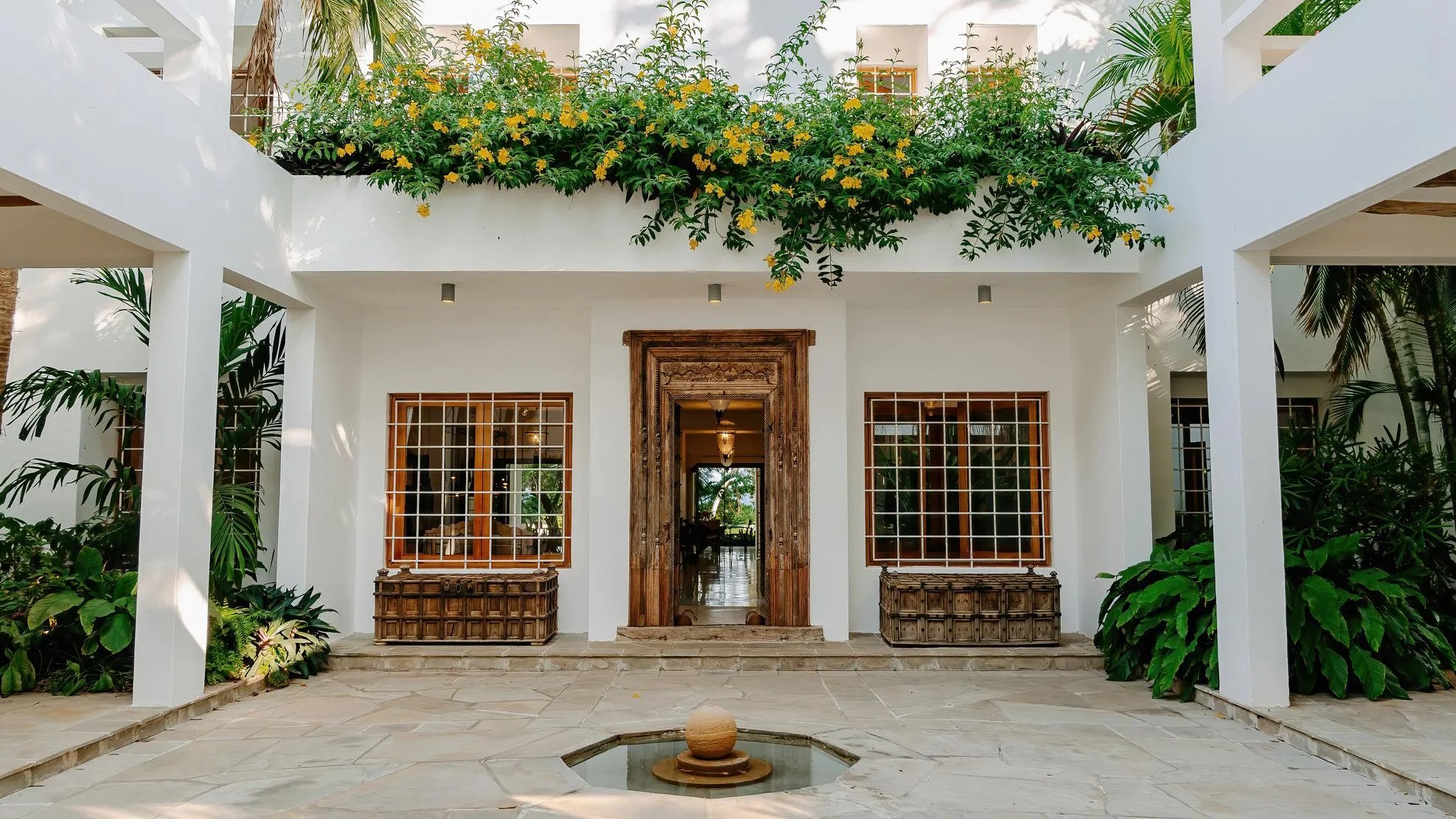 Watamu villa entrance courtyard with wooden door and flowers
